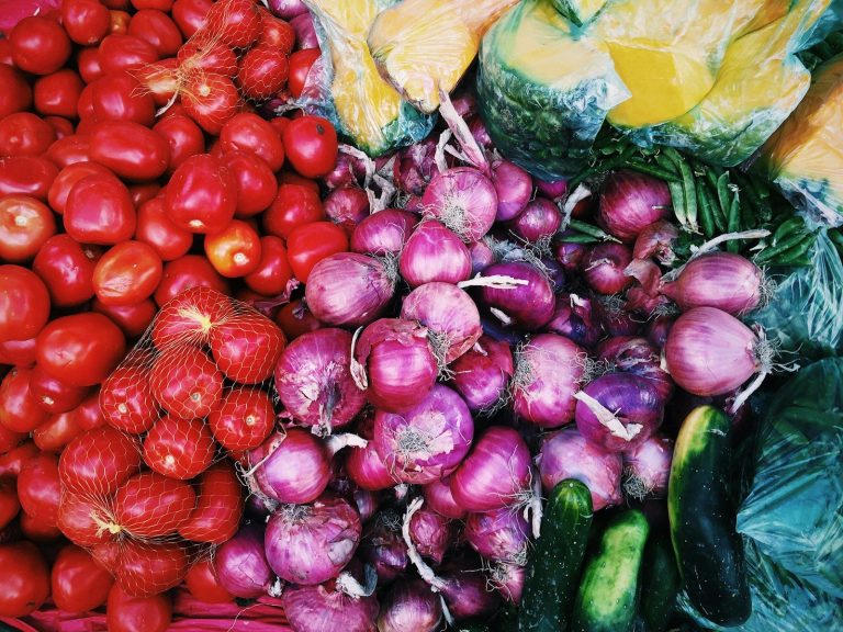 Assorted fresh radishes and other raw vegetables displayed loose.