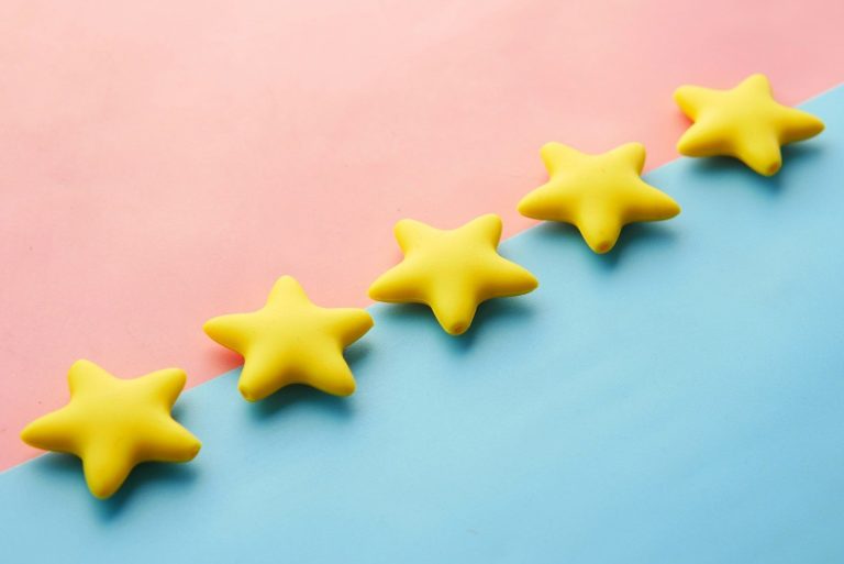 Three yellow star shapes arranged in a row against a pink and blue background.