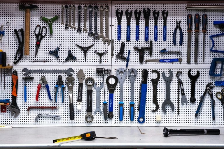 A wall of spanners, pliers and other hand tools neatly arranged on a pegboard so every tool is visible.