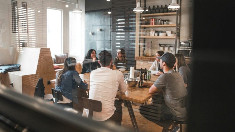 A group of colleagues discussing a project around a meeting table.