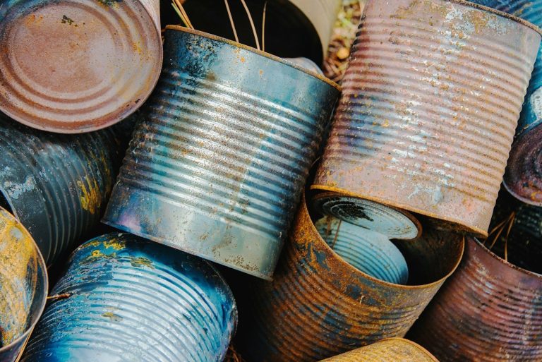 Rusted and corroded metal cans piled together.