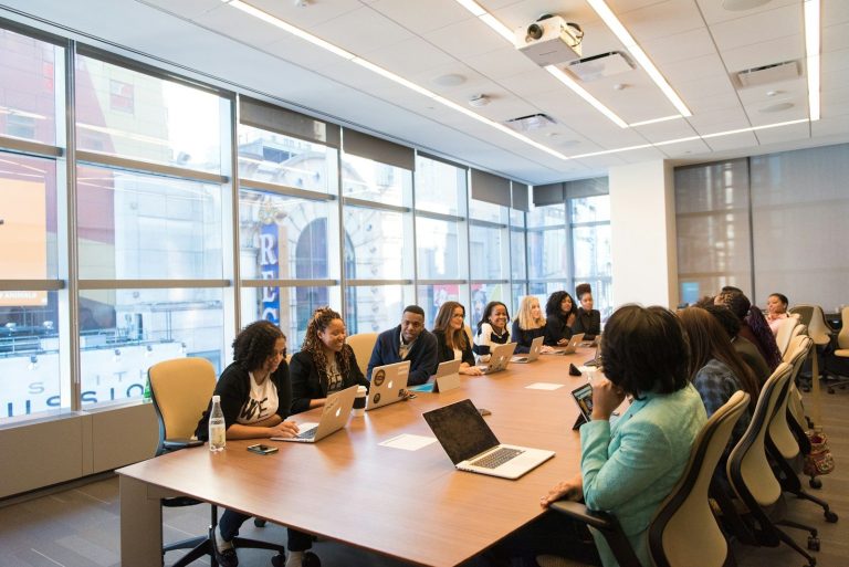 A group of staff seated around a meeting table during a training session.