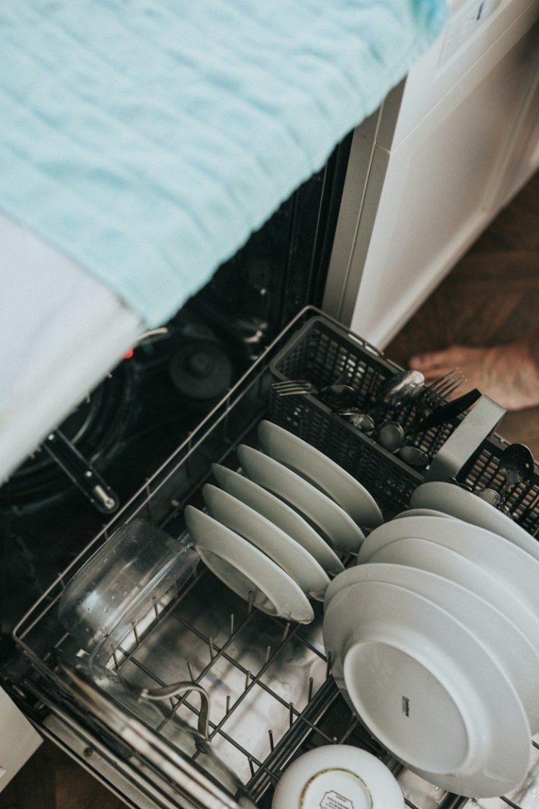 A dishwasher rack loaded with plates and other crockery.