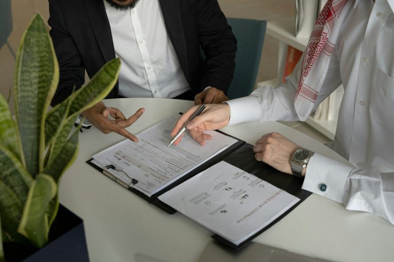 Two people reviewing forms on a clipboard at a table.