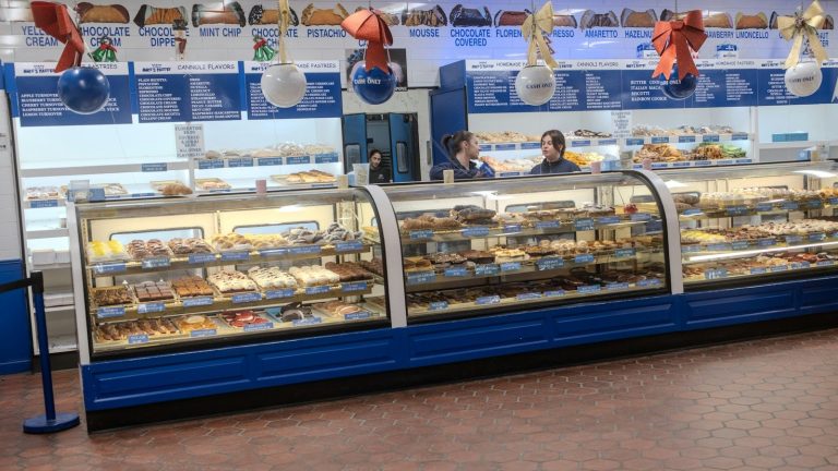A deli counter with a refrigerated display case holding prepared foods for customers to buy.