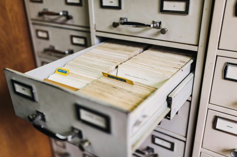 An open filing cabinet drawer packed with index cards and documents.