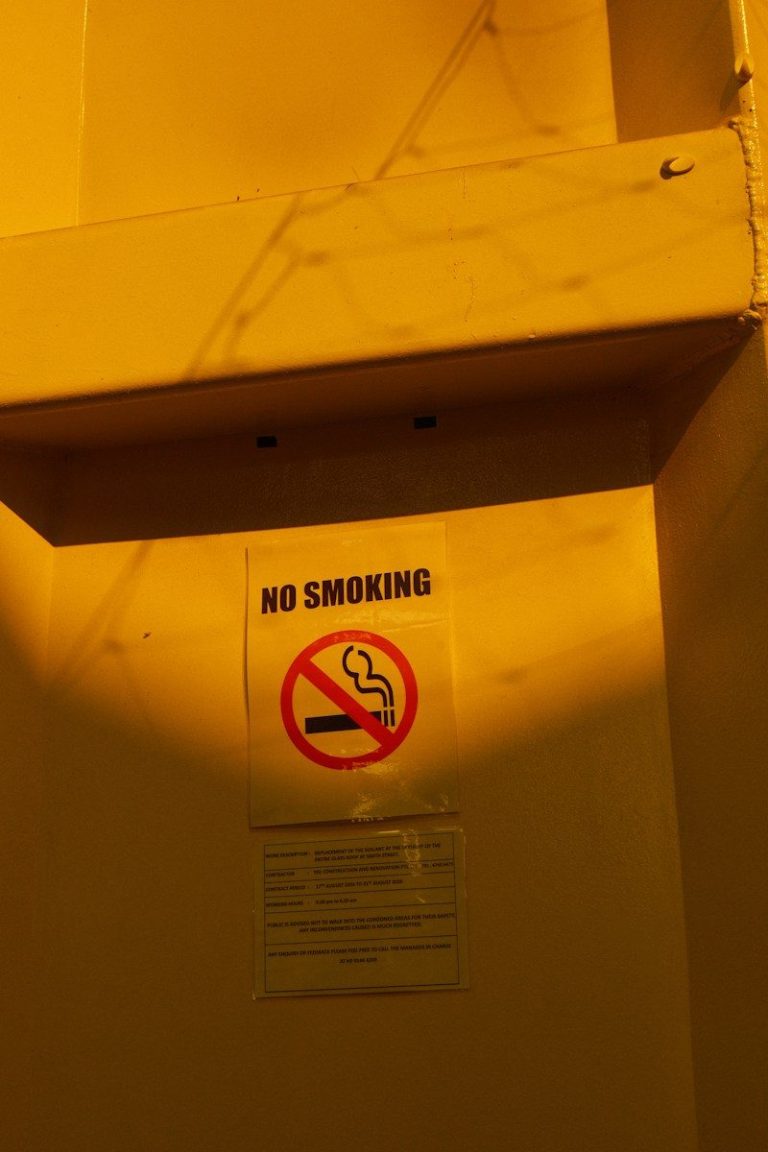 A wall sign showing a no smoking symbol in a workplace.