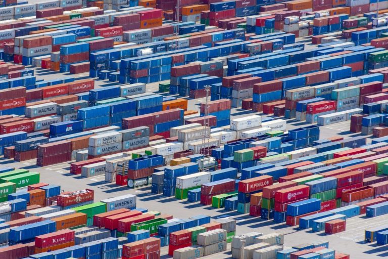 An aerial view of a large container yard with stacked shipping containers.