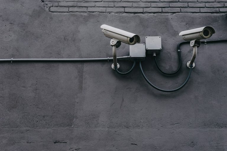 Two security cameras mounted on a grey wall